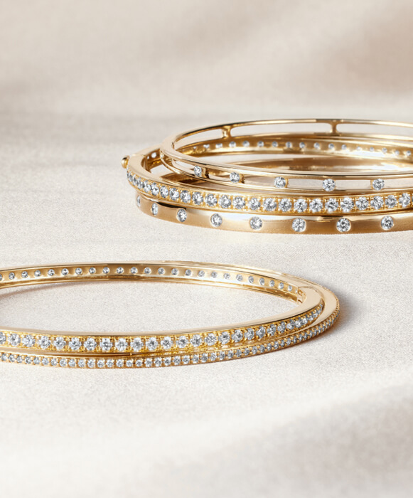 stacked diamond bangles and bracelets in gold