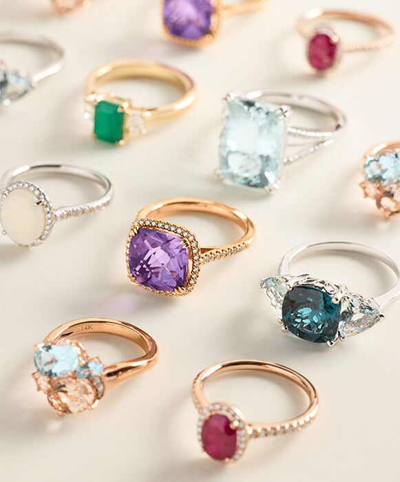 layered gemstone rings in yellow and white gold settings